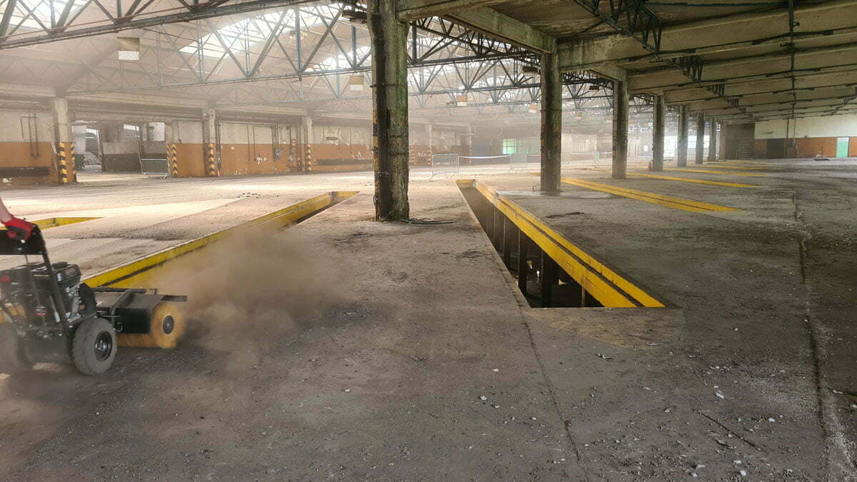 Hala Klienta SolidWork , wielkiej firmy samochodowej z kanałami w betonie i posadzką pokrytą pyłem czekająca na sprzątanie