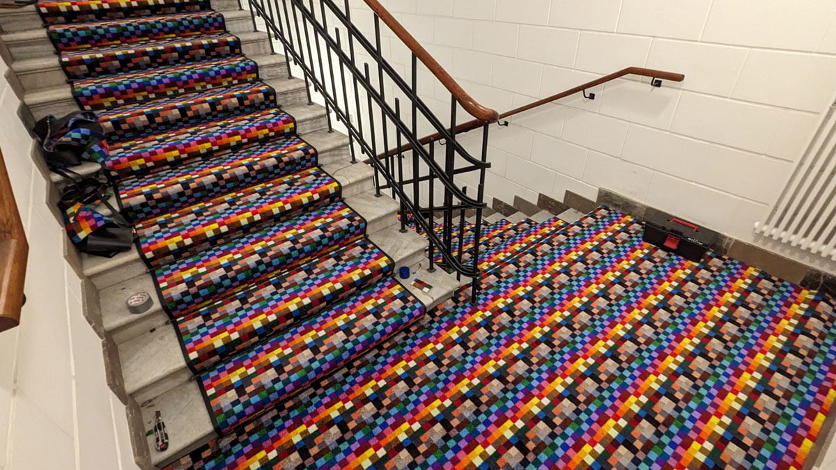 Kolorowe maty dywanowe na klatce schodowej apartamentowca